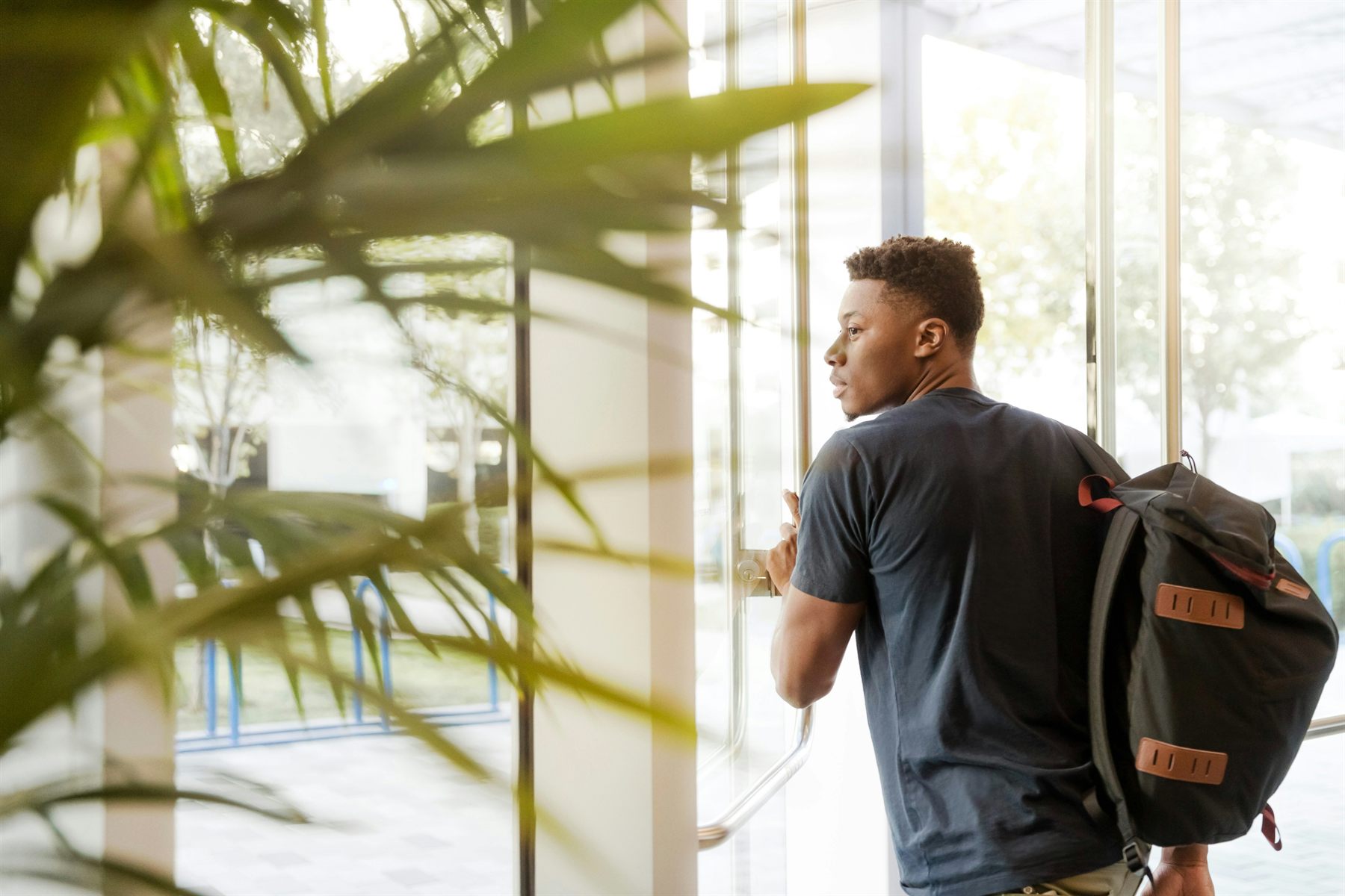 A collegiate student on campus holding a folder